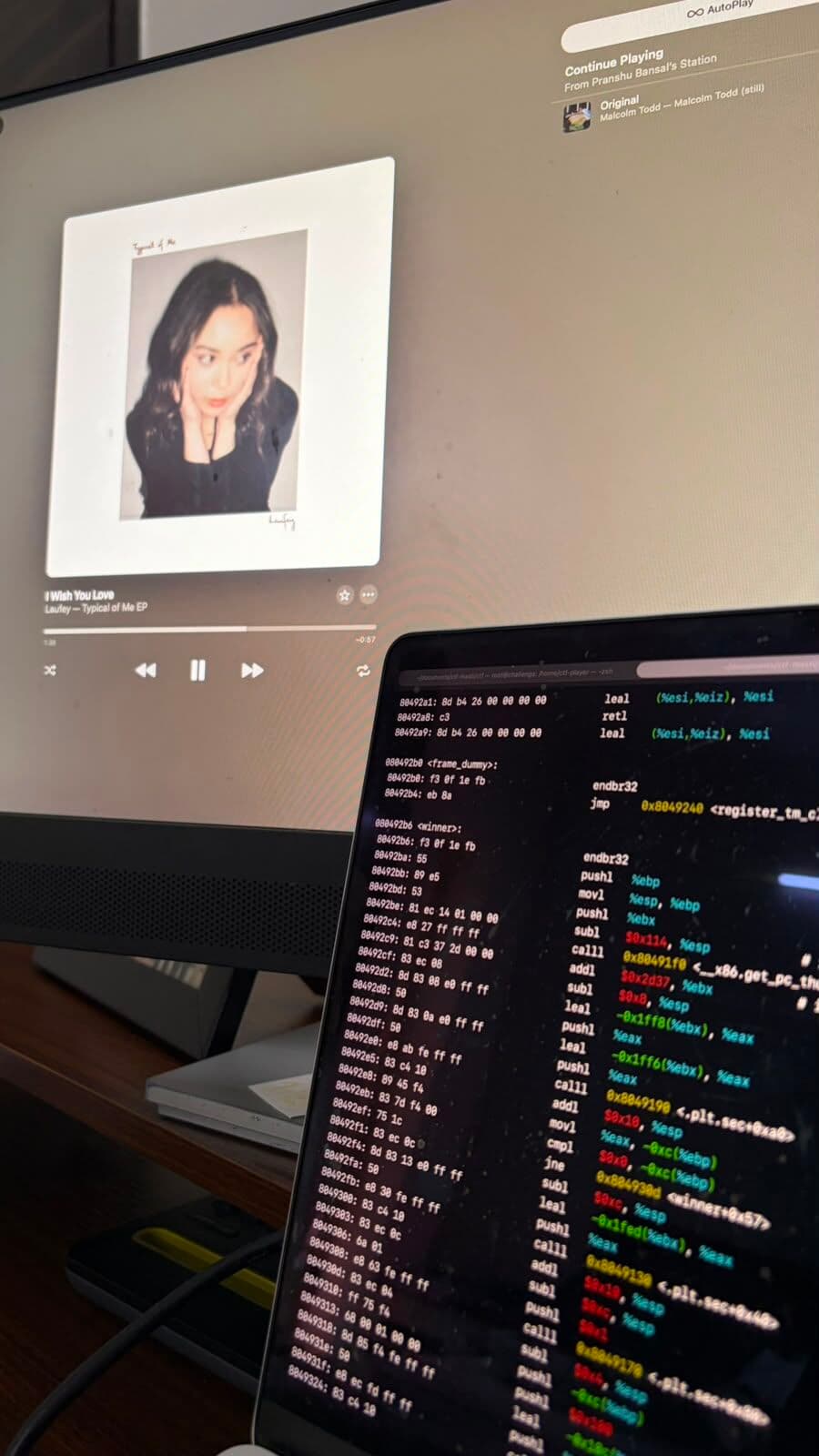 Code running on a laptop beside a music screen
